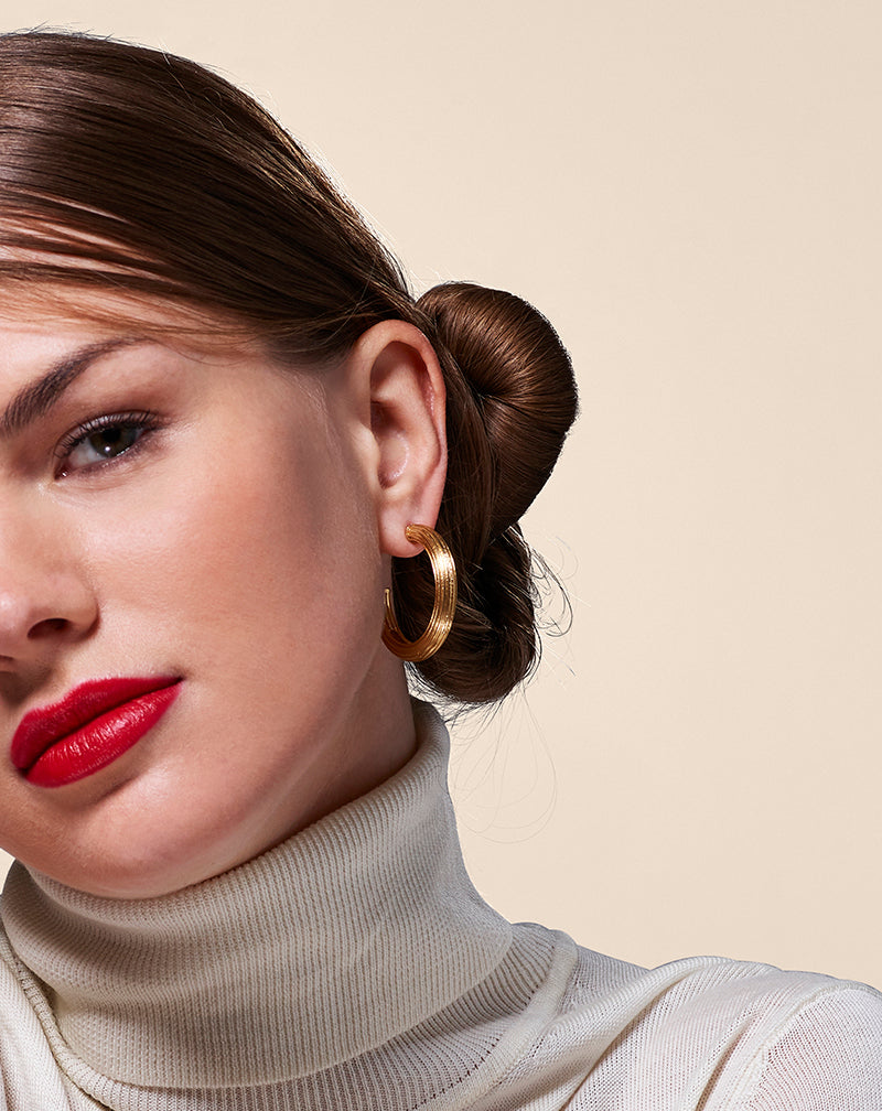Model in white wearing Ribbed Hoop Earring