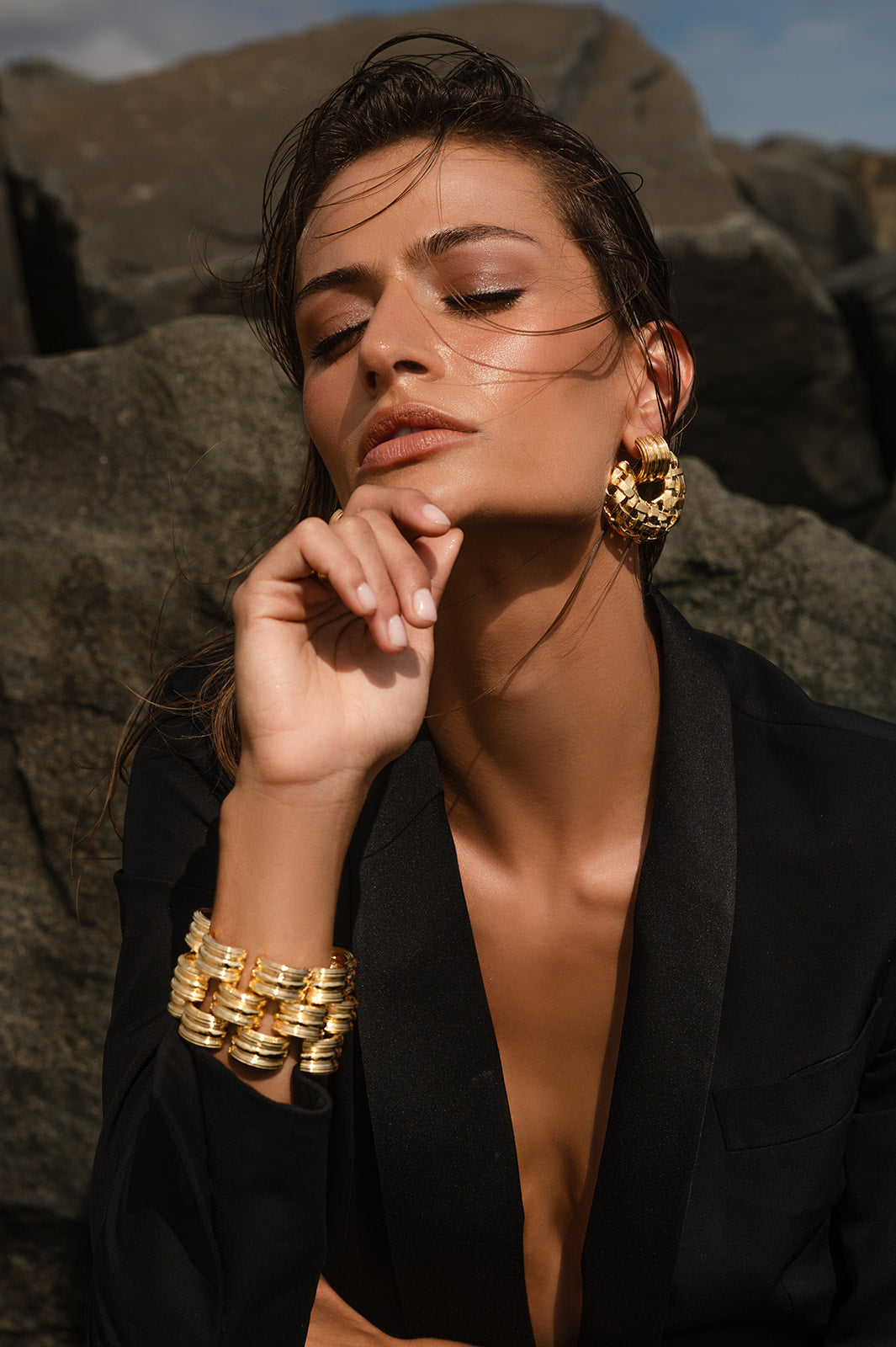 Model wearing a suit wearing Deco Bracelet and earings