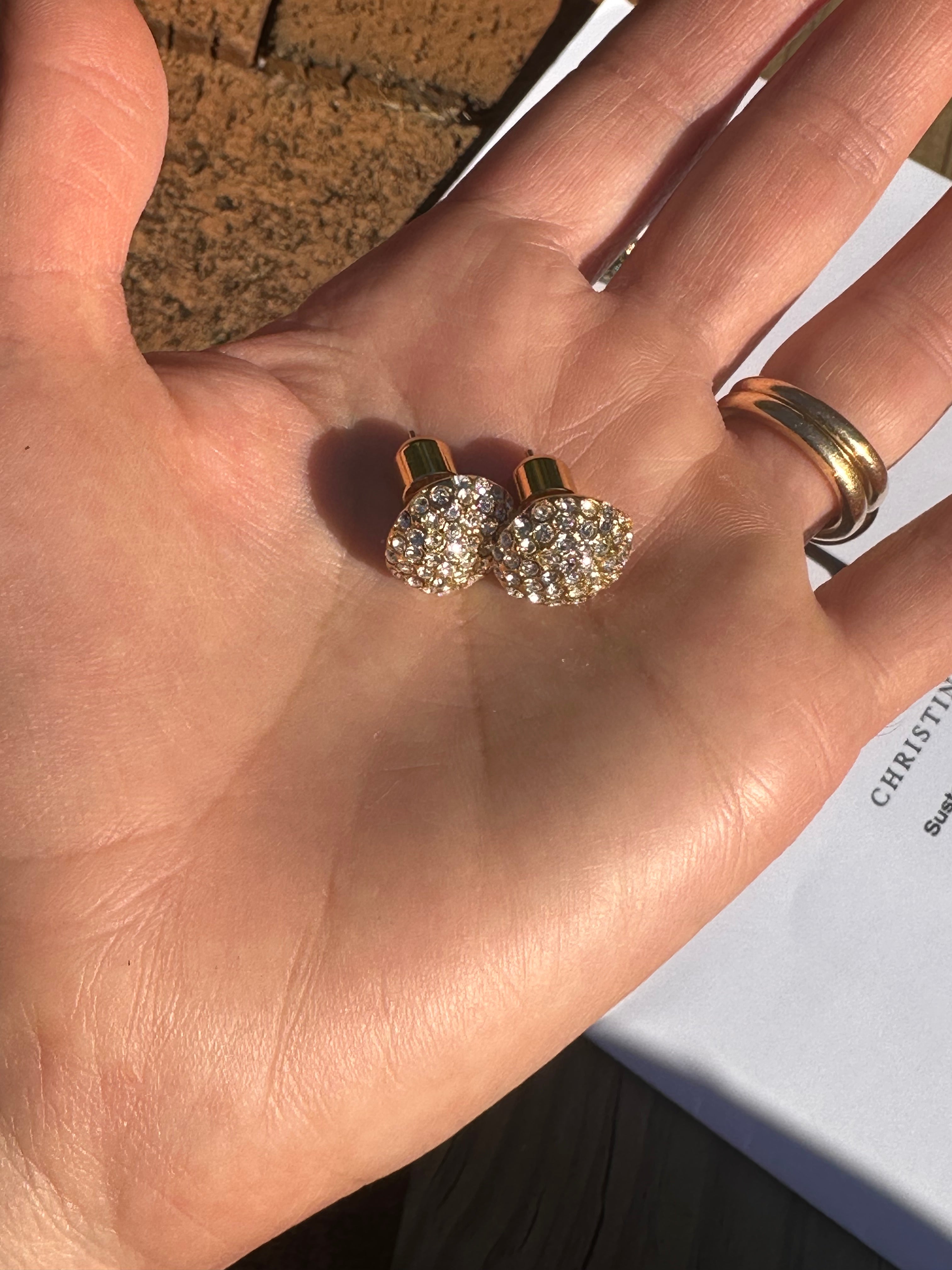 Pave Stud earrings laying on someone's hand