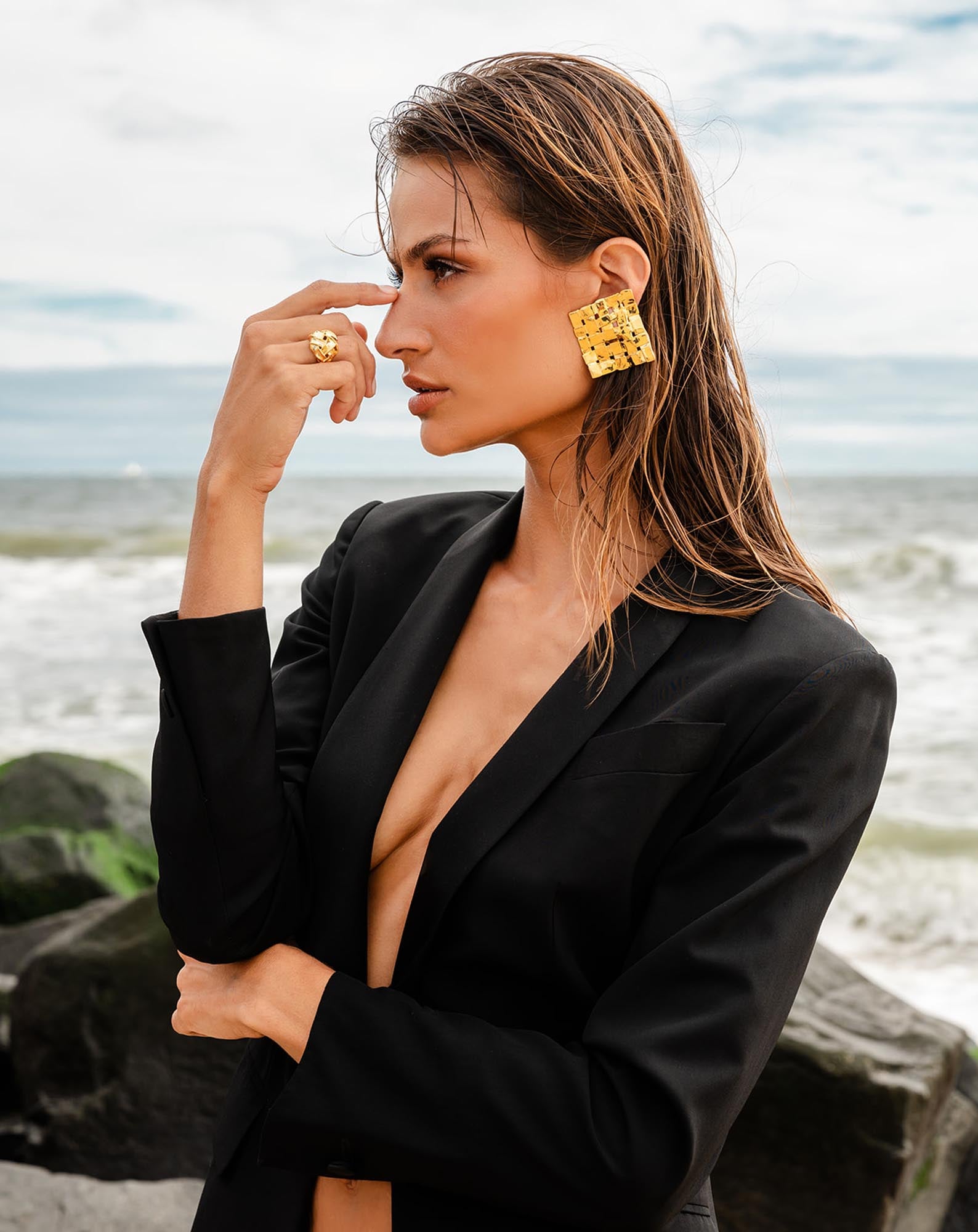 square earring and ring worn by woman in black blazer