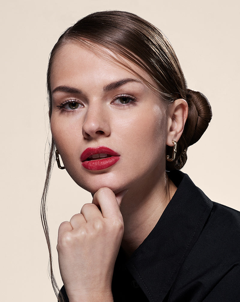 Model in black looking at the camera and wearing Heritage Huggie Earring