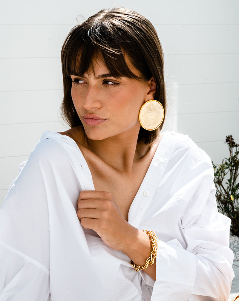 Brunette woman wearing Bezel Set Shell Earring and Chain Link Bracelet